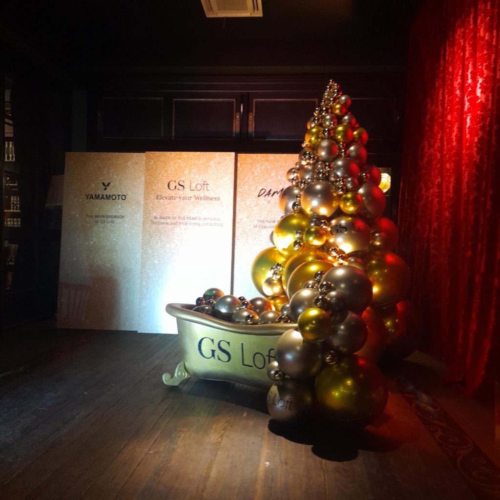 Albero di Natale di palloncini oro e argento che esce da una vasca da bagno con il logo GS Loft