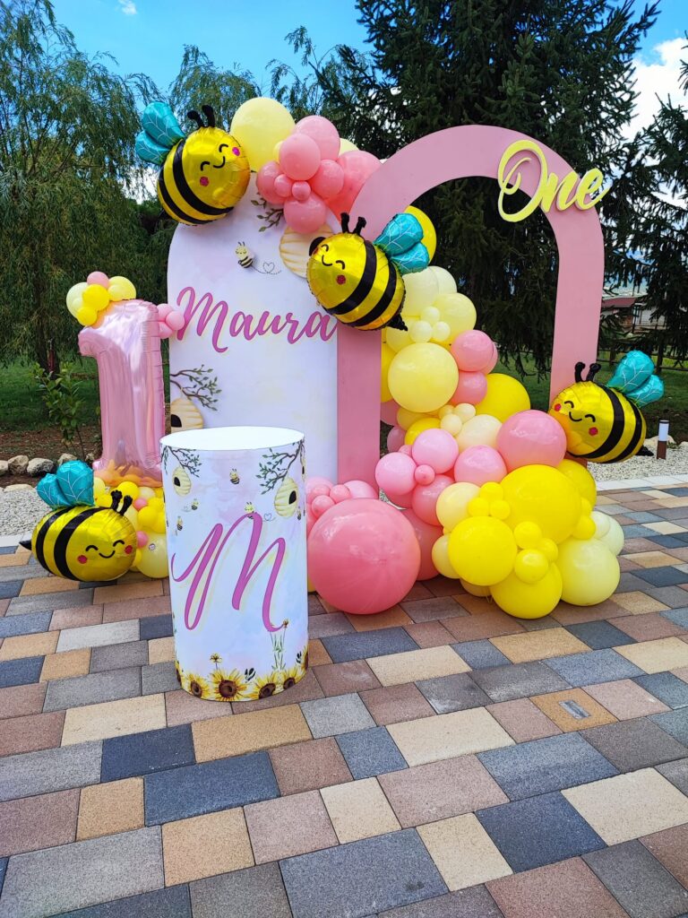 Allestimento a tema api con palloncini gialli e rosa per un primo compleanno